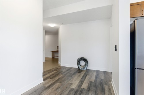 Unfurnished room featuring baseboards and dark wood finished floors - 106 1238 Windermere Way, Edmonton, AB - Indoor