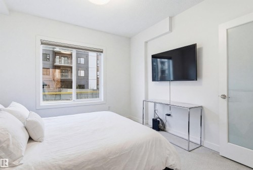 Bedroom featuring light colored carpet and baseboards - 106 1238 Windermere Way, Edmonton, AB - Indoor Photo Showing Bedroom