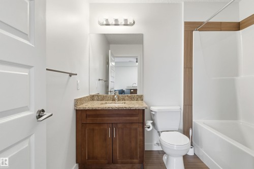 Full bath featuring vanity, dark wood-type flooring, and shower / bath combination - 106 1238 Windermere Way, Edmonton, AB - Indoor Photo Showing Bathroom