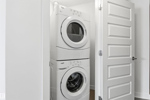 Laundry area featuring stacked washer / drying machine - 106 1238 Windermere Way, Edmonton, AB - Indoor Photo Showing Laundry Room