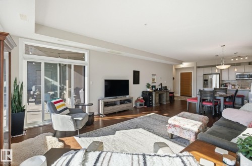 Living area with dark wood-style flooring - 309 625 Leger Way, Edmonton, AB - Indoor Photo Showing Living Room