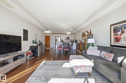 Living room with dark wood-style flooring - 309 625 Leger Way, Edmonton, AB - Indoor Photo Showing Living Room