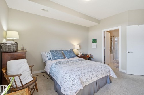 Bedroom featuring light carpet and connected bathroom - 309 625 Leger Way, Edmonton, AB - Indoor Photo Showing Bedroom
