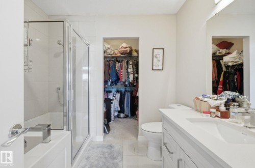 Bathroom featuring a walk in closet, a stall shower, vanity, and a garden tub - 309 625 Leger Way, Edmonton, AB - Indoor Photo Showing Bathroom