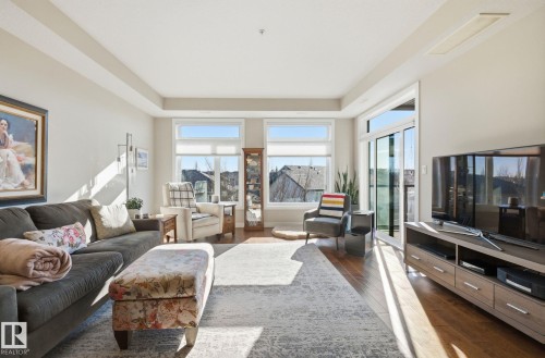 Living area with dark wood-style floors - 309 625 Leger Way, Edmonton, AB - Indoor Photo Showing Living Room