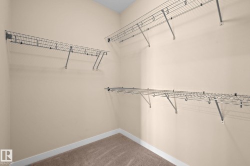 Spacious closet with multiple wire shelving units providing ample storage - 309 625 Leger Way, Edmonton, AB - Indoor With Storage