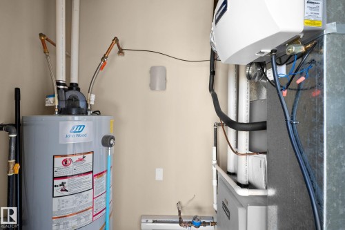 Hot water heater and HVAC system within a utility space - 309 625 Leger Way, Edmonton, AB - Indoor Photo Showing Basement