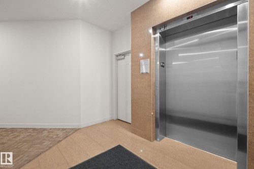 Elevator lobby featuring a stainless steel elevator with a stone-finish surround - 309 625 Leger Way, Edmonton, AB - Indoor Photo Showing Other Room