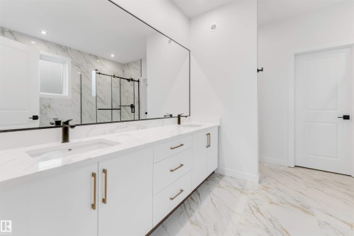 Bathroom with a marble finish shower, double vanity, light marble finish flooring, and recessed lighting - 13 Trill Point(E), Spruce Grove, AB - Indoor