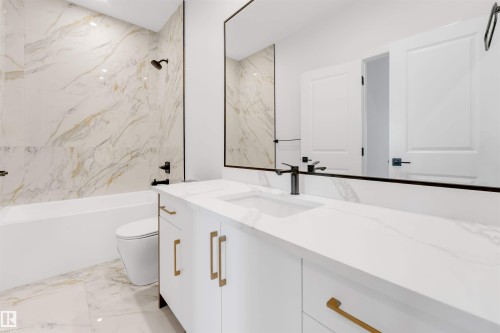 Bathroom with light marble finish flooring, vanity, and a combined bath / shower with marble appearance - 13 Trill Point(E), Spruce Grove, AB - Indoor Photo Showing Bathroom