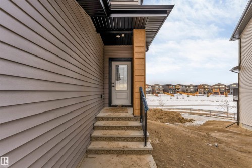 Snow covered property entrance with a residential view - 13 Trill Point(E), Spruce Grove, AB - Outdoor With Exterior
