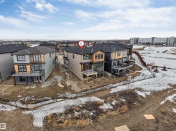 Snow covered rear of property featuring a fenced backyard, a patio, and a balcony - 