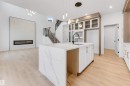 Kitchen featuring a center island with sink, glass insert cabinets, open floor plan, white cabinetry, and light wood finished floors - 13 Trill Point(E), Spruce Grove, AB  - Indoor Photo Showing Kitchen 