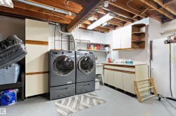 Basement Laundry area with washing machine, clothes dryer and plenty of storage available. - 