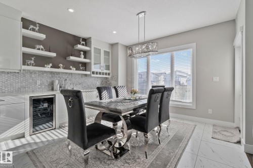 Dining area with light marble finish floors, wine cooler, wet bar, and recessed lighting - 1611 158 Street, Edmonton, AB - Indoor Photo Showing Dining Room