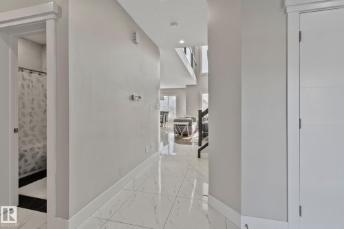 Corridor featuring baseboards and light marble finish flooring - 1611 158 Street, Edmonton, AB - Indoor Photo Showing Other Room