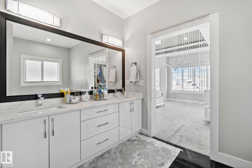 Full bath featuring baseboards and double vanity - 1611 158 Street, Edmonton, AB - Indoor Photo Showing Bathroom