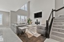 Living area featuring marble look tile flooring, a high ceiling, and a glass covered fireplace - 1611 158 Street, Edmonton, AB  - Indoor With Fireplace 