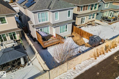 Snow covered rear of property featuring a wooden deck, a shingled roof, a fenced backyard, a residential view, and a storage shed - 1611 158 Street, Edmonton, AB - Outdoor