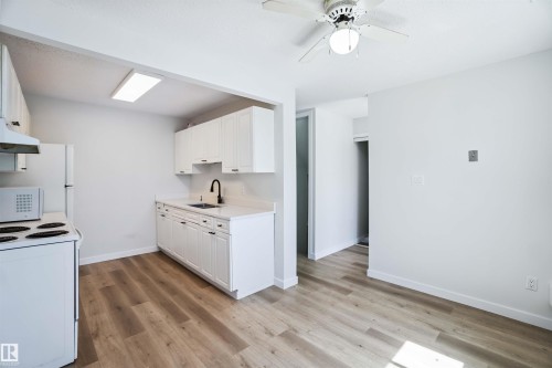 Kitchen featuring white appliances, white cabinetry, light countertops, and a ceiling fan - 1096 Millbourne Road E, Edmonton, AB - Indoor Photo Showing Kitchen