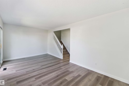 Empty room featuring stairs and wood finished floors - 1096 Millbourne Road E, Edmonton, AB - Indoor Photo Showing Other Room