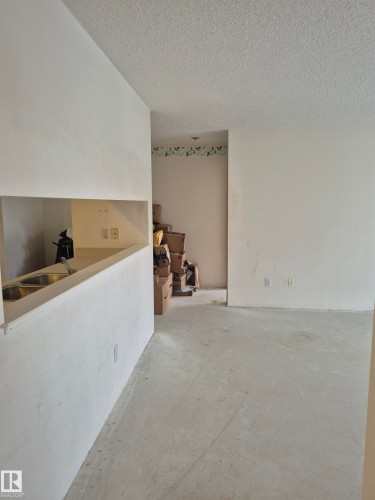 Unfurnished room with a textured ceiling and concrete floors - 410 17467 98A Avenue, Edmonton, AB - Indoor Photo Showing Other Room