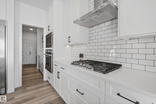 Kitchen with extractor fan, white cabinets, and stainless steel appliances - 9727 205 Street, Edmonton, AB - Indoor Photo Showing Kitchen With Upgraded Kitchen