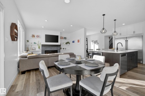 Dining area featuring a tiled fireplace, light wood-type flooring, and recessed lighting - 9727 205 Street, Edmonton, AB - Indoor Photo Showing Dining Room