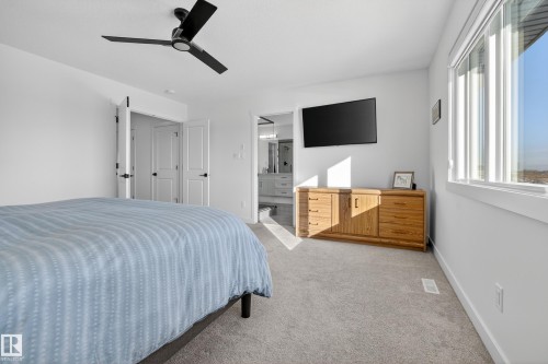 Bedroom with light colored carpet, connected bathroom, and ceiling fan - 9727 205 Street, Edmonton, AB - Indoor Photo Showing Bedroom