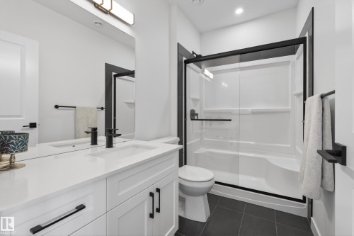 Bathroom featuring a shower stall, vanity, and dark tile patterned floors - 9727 205 Street, Edmonton, AB - Indoor Photo Showing Bathroom