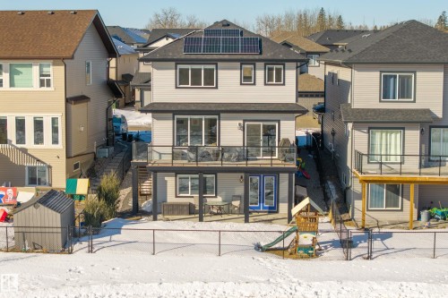 View of front of property featuring a fenced backyard, a patio area, a residential view, and roof mounted solar panels - 9727 205 Street, Edmonton, AB - Outdoor