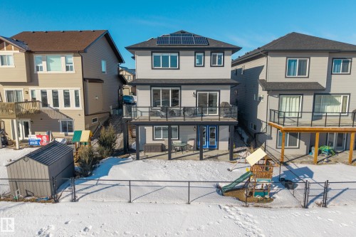 Rear view of house featuring a patio area, a residential view, a gate, roof mounted solar panels, and a playground - 9727 205 Street, Edmonton, AB - Outdoor With Deck Patio Veranda
