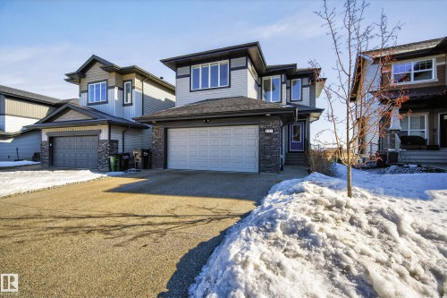 View of front facade featuring stone siding, a garage, and driveway - 9727 205 Street, Edmonton, AB - Outdoor With Facade