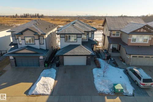 View of front of house with driveway, stone siding, and an attached garage - 9727 205 Street, Edmonton, AB - Outdoor With Facade