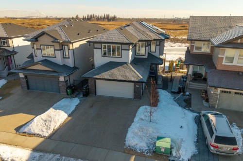 View of front of house with driveway, stone siding, and a garage - 9727 205 Street, Edmonton, AB - Outdoor With Facade
