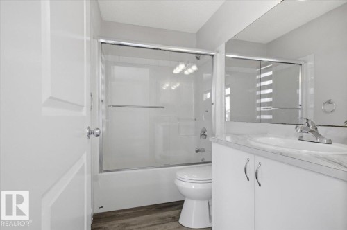 Well-appointed bathroom featuring a vanity with a white countertop and basin, a chrome faucet, and a large mirror - 6 6410 134 Avenue Nw, Edmonton, AB - Indoor Photo Showing Bathroom