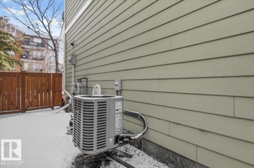 The property features light-colored horizontal siding and a brown wooden fence - 6 6410 134 Avenue Nw, Edmonton, AB - Outdoor With Exterior