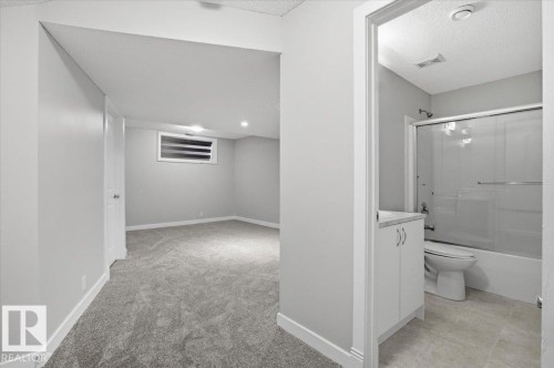 This property features a versatile room with plush carpeting and a window for natural light - 6 6410 134 Avenue Nw, Edmonton, AB - Indoor