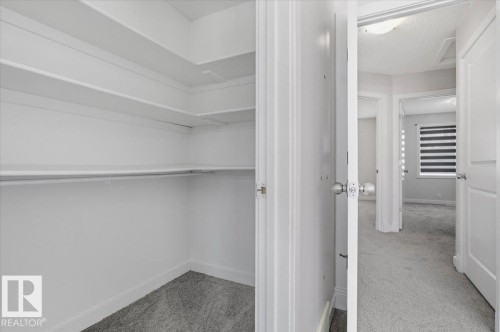 Closet featuring white shelving and a hanging rod, with gray carpet flooring - 6 6410 134 Avenue Nw, Edmonton, AB - Indoor With Storage