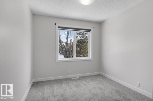 Room with light gray walls, gray carpet, a white framed window, and a ceiling light fixture - 6 6410 134 Avenue Nw, Edmonton, AB - Indoor Photo Showing Other Room