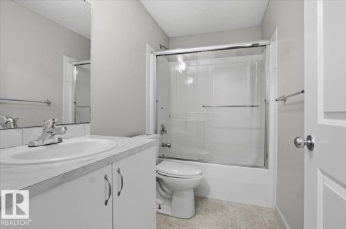 Bathroom with a full vanity, mirror, and a shower with sliding glass doors - 6 6410 134 Avenue Nw, Edmonton, AB - Indoor Photo Showing Bathroom
