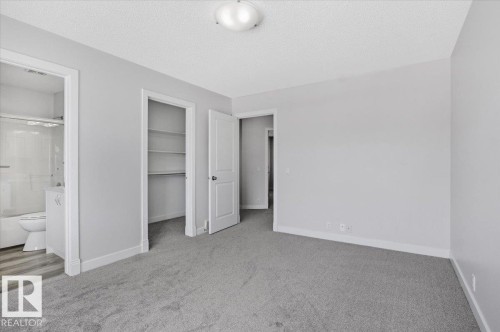 The room features light gray carpeting and white painted walls, providing a neutral aesthetic - 6 6410 134 Avenue Nw, Edmonton, AB - Indoor Photo Showing Other Room