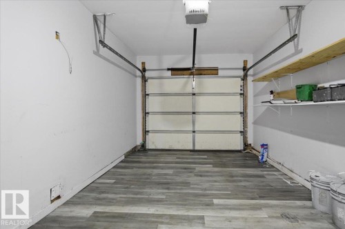 The garage features light-colored walls, gray flooring, and a garage door - 6 6410 134 Avenue Nw, Edmonton, AB - Indoor Photo Showing Garage