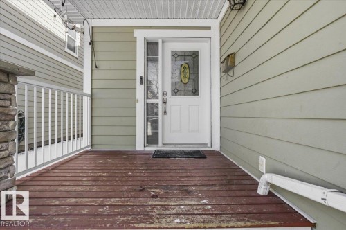 The property features a front entrance with a decorative glass panel door and a covered porch with a wood floor - 6 6410 134 Avenue Nw, Edmonton, AB - Outdoor With Exterior