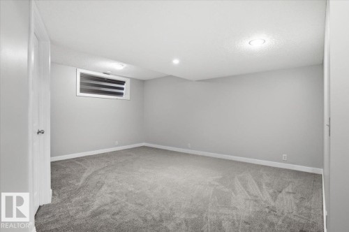 This versatile room features light grey walls and plush grey carpeting - 6 6410 134 Avenue Nw, Edmonton, AB - Indoor