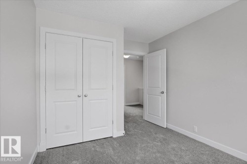 Room featuring light grey walls and grey carpet flooring - 6 6410 134 Avenue Nw, Edmonton, AB - Indoor