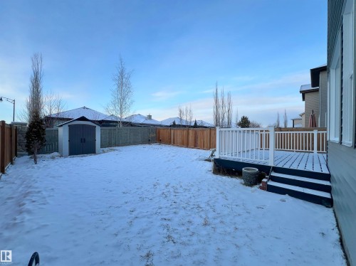 Yard covered in snow with a wooden deck, a shed, and a fenced backyard - 4604 Westcliff Point(E), Edmonton, AB - Outdoor With Backyard