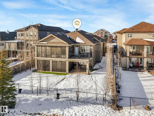 Snow covered house with a residential view and a sunroom - 117 Mcdowell Wynd, Leduc, AB - Outdoor With Deck Patio Veranda