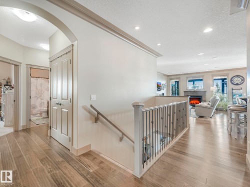 Corridor featuring arched walkways, light wood-style floors, an upstairs landing, a textured ceiling, and recessed lighting - 117 Mcdowell Wynd, Leduc, AB - Indoor Photo Showing Other Room
