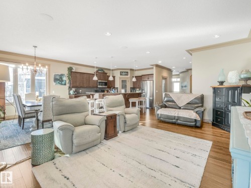 Living room with hanging lights, light wood-type flooring, and crown molding - 117 Mcdowell Wynd, Leduc, AB - Indoor Photo Showing Living Room